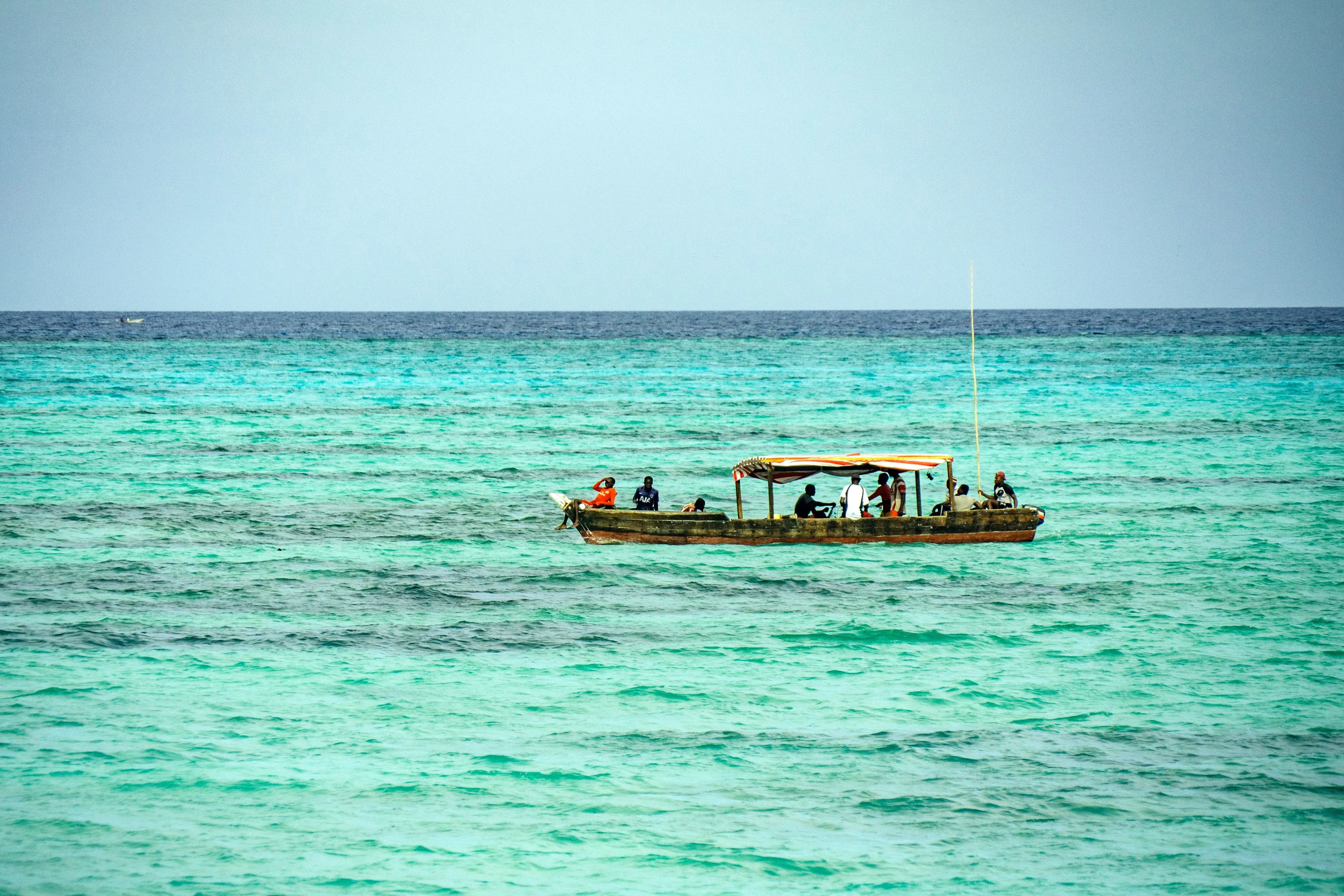Traditional boat crossing the turquoise water off Zanzibar